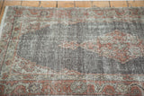 Distressed pile texture of a Vintage Oushak rug, with faded brick red and chocolate patterns.
