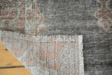 Vintage Oushak rug folded, highlighting distressed pile with visible foundation.