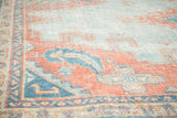 Distressed hand-knotted Turkish Oushak carpet detail, showing subtle sky blue and peach motifs.