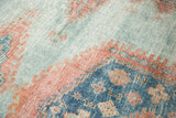 Distressed Oushak rug pile with subtle sky blue, peachy blush, and deep blue motifs.
