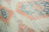 Textured view of distressed vintage Oushak rug in sky blue and peachy blush tones.