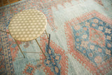 Textured distressed vintage Oushak rug showing sky blue and peach geometric motifs.