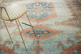 Faded sky blue and peachy blush geometric patterns on a distressed vintage Oushak carpet.