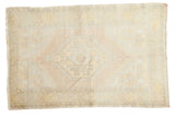 Vintage Oushak distressed rug featuring an octagonal medallion in muted blush, saffron, and ivory.