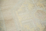 Textured pile of distressed Oushak rug in muted ivory and faded saffron yellow.