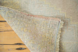 Secured edge, hand-knotted reverse, and fringe of a distressed vintage Oushak rug.
