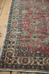 Distressed cherry red Oushak rug field, showing scrolling palmettes and a multi-color border.