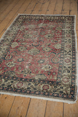Heavy distress on vintage Oushak rug, showcasing faded cherry red field and scrolling palmette patterns.
