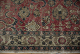 Distressed Oushak rug border featuring beige ground, dark floral patterns, and fringe.