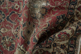 Distressed Oushak rug's textured pile, showcasing intricate red and beige curvilinear patterns.