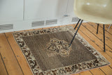 Vintage Oushak rug corner with chocolate brown grape leaf border and repeating beige pearl field.