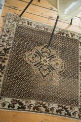 Vintage Oushak rug corner with interconnected grape leaf border and repeating pearl field.