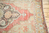 Distressed texture and secured edge of vintage Oushak rug with intricate beige, red border.