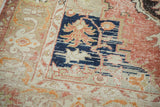 Close-up of a distressed Oushak rug, showing faded cinnabar red, navy blue, and beige floral abrash.