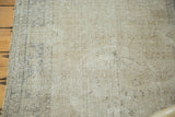 Distressed texture dominating the faded sand and beige palette of a vintage Oushak rug.
