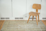 Distressed vintage Oushak rug in soft earth tones, highlighting its faded texture.