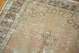 Distressed copper blush and chocolate brown motifs on an Oushak rug, showing exposed foundation.