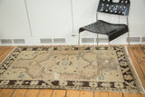 Vintage distressed Oushak rug featuring an ornate medallion, ivory field, and dark chocolate border.