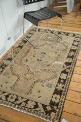 Distressed pile and secure fringe of a vintage Oushak rug, with dark brown border.