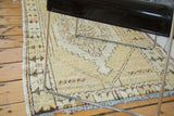 Distressed vintage Oushak rug, bottom corner with faded saffron, beige, brown geometric patterns.