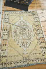 Distressed vintage Oushak rug detail with faded saffron, beige, and brown stepped medallion.