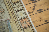 Secured side, short fringe, and faded floral pattern on distressed vintage Oushak rug.