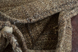 Speckled, hand-loomed goat hair texture with a visible stitched fold on the vintage grainbag.