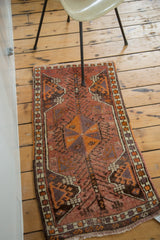 Vintage Oushak rug corner, multicolored selvedge, fringed end, and rust tangerine geometric border.