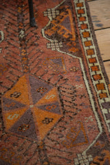 Geometric border detail of vintage Oushak rug with elongated flowers in rust, tangerine, and eggplant.