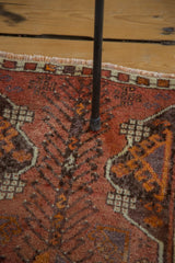 Oushak rug detail: rust, chocolate brown, and faded silver eggplant tendrils. Multicolored selvedge.