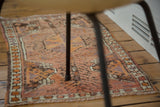 Vintage Oushak rug mat with prominent rust and orange tones and multicolored selvedge.