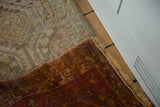 Hand-knotted Oushak rug end detail with original fringe and rich red, gold tones.