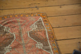 Distressed vintage Oushak rug corner, showing multicolored selvedge with madder red and tangerine orange.