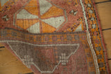Distressed tangerine and red Oushak rug pile, revealing hand-knotted back and vibrant selvedge.