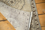 Distressed vintage Oushak rug showing its hand-knotted construction and beige geometric pile.