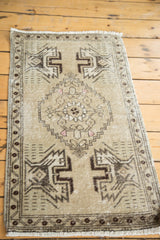 Distressed vintage Oushak mat with beige field, geometric medallion and planter motifs.