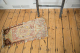 Faded brown and blue geometric rams horn design on one end of the distressed Oushak runner.