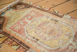 Textured distressed Oushak rug pile with faded saffron yellow and cranberry motifs.
