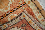 Vintage Oushak rug corner with plush tangerine pile, ivory patterns, and brown side cord.