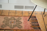 Vintage Oushak rug end featuring chocolate brown and bright tangerine geometric patterns.