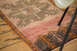 Hand-knotted Oushak rug corner, faded brick red field, tangerine orange serrated border.