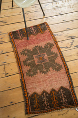 Vintage Oushak rug corner with chocolate brown plant motifs and orange selvedge.