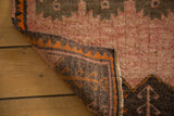 Folded corner of a Vintage Oushak rug, revealing multicolor cord selvedge and geometric underside pattern.