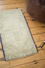 Faded beige and blush Oushak rug surface with subtle pattern and original blue selvedge.