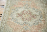 Hand-knotted Oushak rug pile showcasing expressive undulating blush and seafoam motifs.