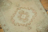 Vintage Oushak rug's expressive scrolling medallion outline in faded blush and ivory.