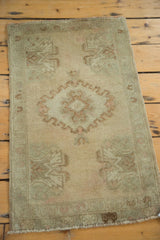 Vintage Oushak rug's bottom corner, featuring faded germinating flower motif and fringe.