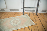 Vintage Oushak runner's distressed pile in muted blush, sea foam green, and silver.