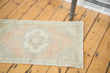 Faded blush and sea foam green distressed pile with checkered corner pattern detail.