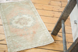 Vintage distressed Oushak rug, featuring a subtle crab medallion in faded blush and sea foam.